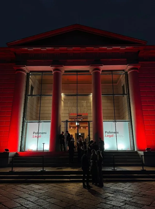 Una serata di Polimeni.Legal: la facciata neoclassica della sede illuminata di rosso, con gli ospiti all'ingresso